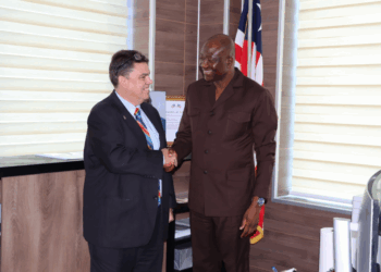 CBL Governor Henry Saamoi shakes hands with U.S. Embassy Charge d’Affaires Joseph E. Zadrozny in Monrovia during talks on gold reserves and financial cooperation