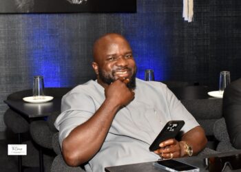 Wellington Railey, a former Liberian journalist now a U.S.-based entrepreneur, smiling while seated during a visit to Liberia, where he is building a 60-bed hospital in Johnsonville to boost local healthcare and answer President Boakai’s call for diaspora investment.