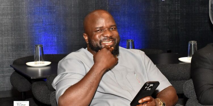 Wellington Railey, a former Liberian journalist now a U.S.-based entrepreneur, smiling while seated during a visit to Liberia, where he is building a 60-bed hospital in Johnsonville to boost local healthcare and answer President Boakai’s call for diaspora investment.
