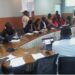 Participants of the multistakeholder dialogue in Monrovia seated in a conference room during discussions on land governance jobs for graduates, followed by a group photo outside with civil society leaders, educators, students, and international partners.