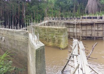 Unfinished bridge construction in Douta, Bong County, Liberia, where residents risk deadly creek crossings on a fragile wooden structure due to stalled works.