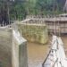 Unfinished bridge construction in Douta, Bong County, Liberia, where residents risk deadly creek crossings on a fragile wooden structure due to stalled works.