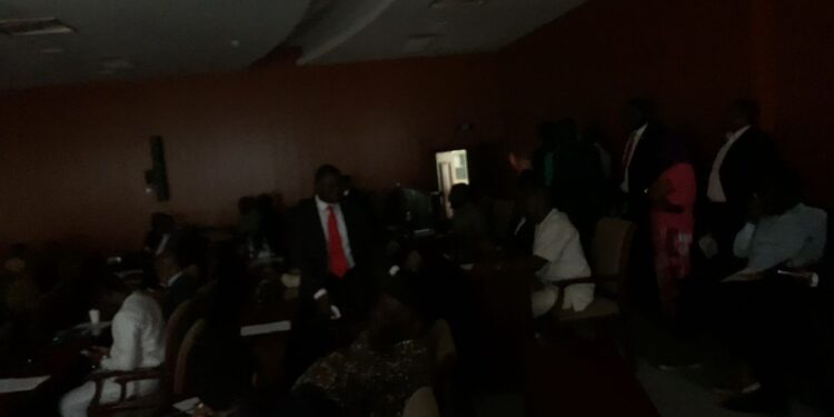 Lawmakers at Liberia’s Capitol Hill chamber sit in partial darkness during a 30-minute power outage as House Chair James Kolleh coordinates restoration efforts