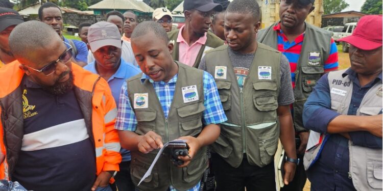 EPA Executives inspect containers during the probe into Elsin Transport’s alleged unauthorized disposal of palm-kernel shells in Paynesville.