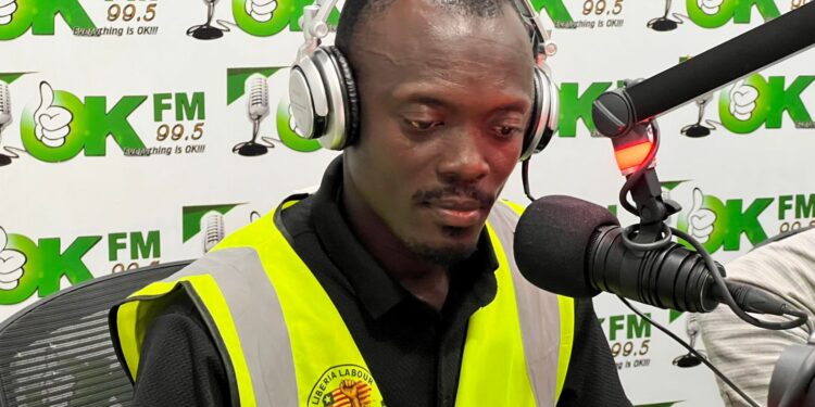 Labour rights advocate George S. Tengbeh of LILGA speaks during a radio interview after receiving death threats for exposing workplace abuses in Liberia