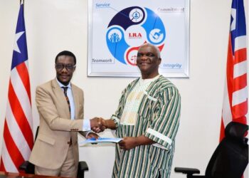 LSEZA Executive Chairman Prince Wreh and LRA Commissioner General James Dorbor Jallah shaking hands after signing a landmark MOU to boost trade, investment, and special economic zones in Liberia