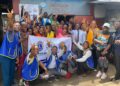 Members of the Paynesville Boulevard Omega Leos Club pose with community residents in West Point after a one-day mental health awareness campaign.