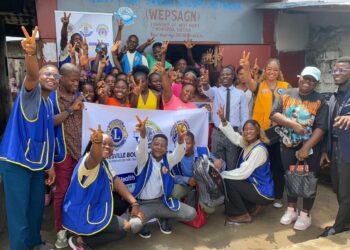 Members of the Paynesville Boulevard Omega Leos Club pose with community residents in West Point after a one-day mental health awareness campaign.