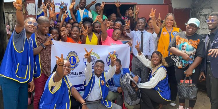 Members of the Paynesville Boulevard Omega Leos Club pose with community residents in West Point after a one-day mental health awareness campaign.