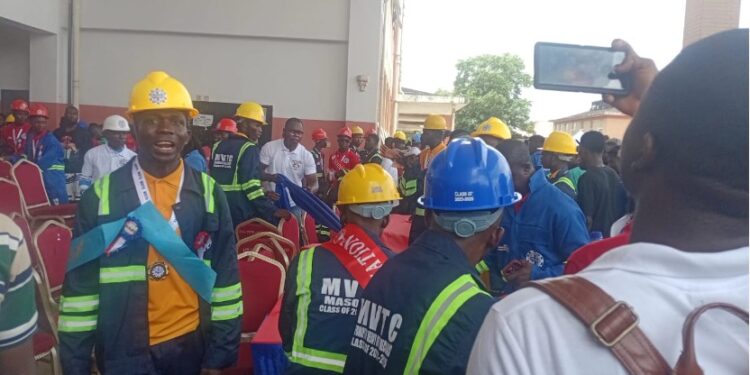 MVTC graduates in helmets and protective gear protesting during the 4th Circle Graduation in Monrovia over missing souvenirs and poor planning