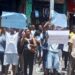 Street vendors in Monrovia hold placards during a protest on Michelin Street, appealing to President Boakai for relief after police raids disrupted their trade