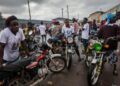 Young commercial motorbike riders in Gbarnga gather roadside, many forced to abandon higher education to earn a living through riding