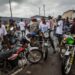 Young commercial motorbike riders in Gbarnga gather roadside, many forced to abandon higher education to earn a living through riding