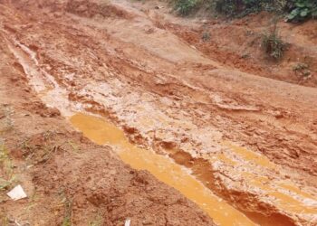 A muddy, impassable rural road in Garyea Clan, Bong County, showing deep erosion and stagnant water after heavy rains