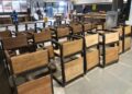 Rows of newly built wooden-and-metal classroom chairs at the Monrovia Vocational Training Center workshop, produced under the “One Chair, One Child” program funded by salaries withheld from suspended Liberian government officials