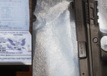 A Liberian passport belonging to James Mulbah Bowah displayed alongside the SMITH & WESSON pistol seized at Roberts International Airport during an alleged firearm smuggling investigation by the Liberia National Police