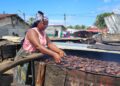 A Liberian woman fishmonger in Marshall, Margibi County, prepares smoked fish as part of a World Bank–funded empowerment project for coastal women traders