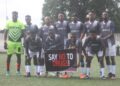 Liberian football players pose before a match holding a banner that reads “Say No to Drugs,” as the LFA launches its new anti-doping initiative