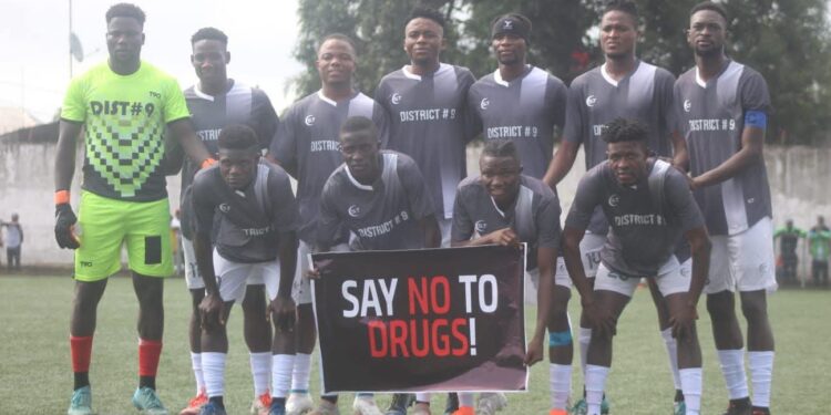 Liberian football players pose before a match holding a banner that reads “Say No to Drugs,” as the LFA launches its new anti-doping initiative