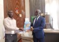 Integrity Watch Liberia Executive Director Harold Aidoo presents the 2026 Budget Option Paper to House Speaker Richard Koon at the Capitol Building in Monrovia.
