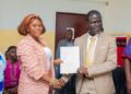 EPA Executive Director Dr. Emmanuel Urey Yarkpawolo and Project Lead Vermon Sangah Lloyd exchange documents during the signing of a waste management MOU in Monrovia