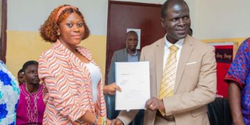 EPA Executive Director Dr. Emmanuel Urey Yarkpawolo and Project Lead Vermon Sangah Lloyd exchange documents during the signing of a waste management MOU in Monrovia