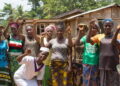 Rural women in Western Liberia raise their hands in solidarity during a community meeting, calling on President Joseph Boakai for financial empowerment and market support