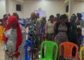 Women at Conquering Tabernacle Ministry International standing in prayer during a faith-driven workshop organized by A New Day Advocacy to support Liberia’s drug-affected youth and families
