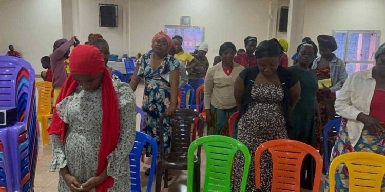 Women at Conquering Tabernacle Ministry International standing in prayer during a faith-driven workshop organized by A New Day Advocacy to support Liberia’s drug-affected youth and families