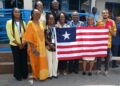 Liberian delegation and Ambassador Musu Jatu Ruhle pose with national flag at Kaizen public-sector training in Accra, Ghana.