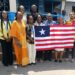 Liberian delegation and Ambassador Musu Jatu Ruhle pose with national flag at Kaizen public-sector training in Accra, Ghana.
