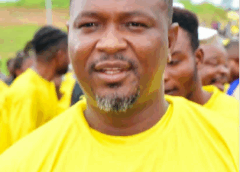 A community figure in a yellow shirt speaks at a public event in Nimba County