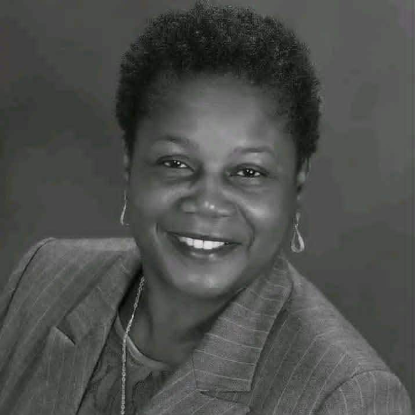 Dr. Augurie E. Stevens in professional attire smiling in a posed studio portrait.