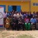 A group of people gathered in front of a building during a nursing and midwifery conference event