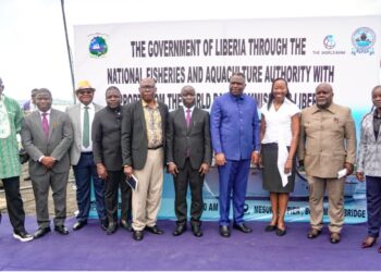 A group of people standing together at an outdoor commissioning ceremony for a national fisheries project