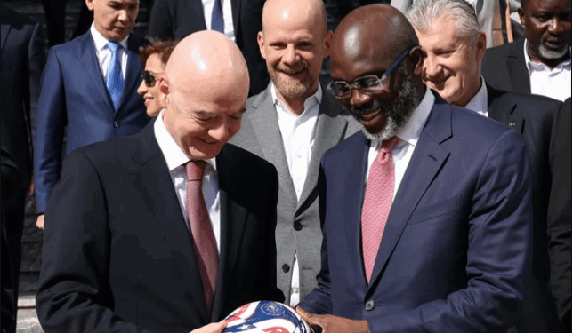 George Weah receives a football from FIFA President Gianni Infantino during a panel session on ending racism in football in Rabat, Morocco.