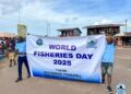 Two participants hold a banner reading “World Fisheries Day 2025” during Liberia’s first-ever national celebration.