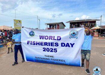 Two participants hold a banner reading “World Fisheries Day 2025” during Liberia’s first-ever national celebration.