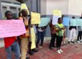 Community members hold placards during a NUCFDC protest over delayed forest benefit payments in Monrovia.