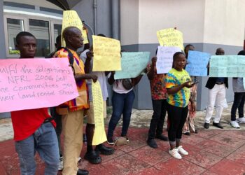 Community members hold placards during a NUCFDC protest over delayed forest benefit payments in Monrovia.