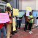 Community members hold placards during a NUCFDC protest over delayed forest benefit payments in Monrovia.