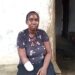 A woman with a bandaged arm sits outside her home in Todee District after a factory accident left her disabled.