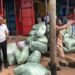 People standing near bundled goods in a busy market area during an eviction operation