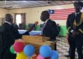 Chief Justice Yamie Quiqui Gbeisay administers an oath during a court ceremony in Kakata, Margibi County, as officers and dignitaries look on under the Liberian flag