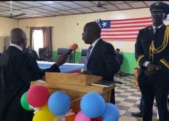 Chief Justice Yamie Quiqui Gbeisay administers an oath during a court ceremony in Kakata, Margibi County, as officers and dignitaries look on under the Liberian flag