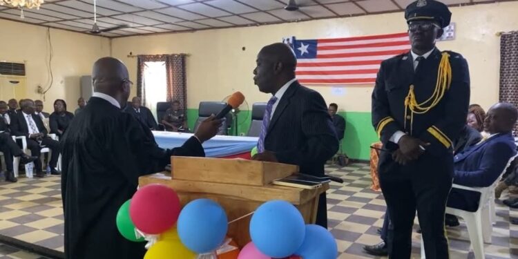 Chief Justice Yamie Quiqui Gbeisay administers an oath during a court ceremony in Kakata, Margibi County, as officers and dignitaries look on under the Liberian flag