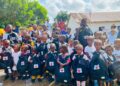 Group of Bentol City schoolchildren holding Red Cross-branded book bags during a school-supply distribution supported by the Red Cross and Yayeh Initiative.