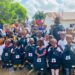 Group of Bentol City schoolchildren holding Red Cross-branded book bags during a school-supply distribution supported by the Red Cross and Yayeh Initiative.