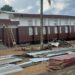 Workers installing panels at D. Twe High School during a renovation project criticized for substandard materials and poor supervision.