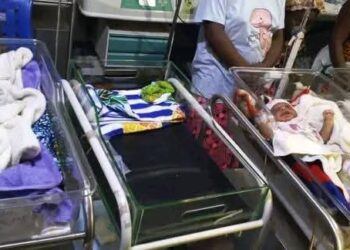 Hospital bassinets with newborn babies as health workers look on at Zwedru medical facility.